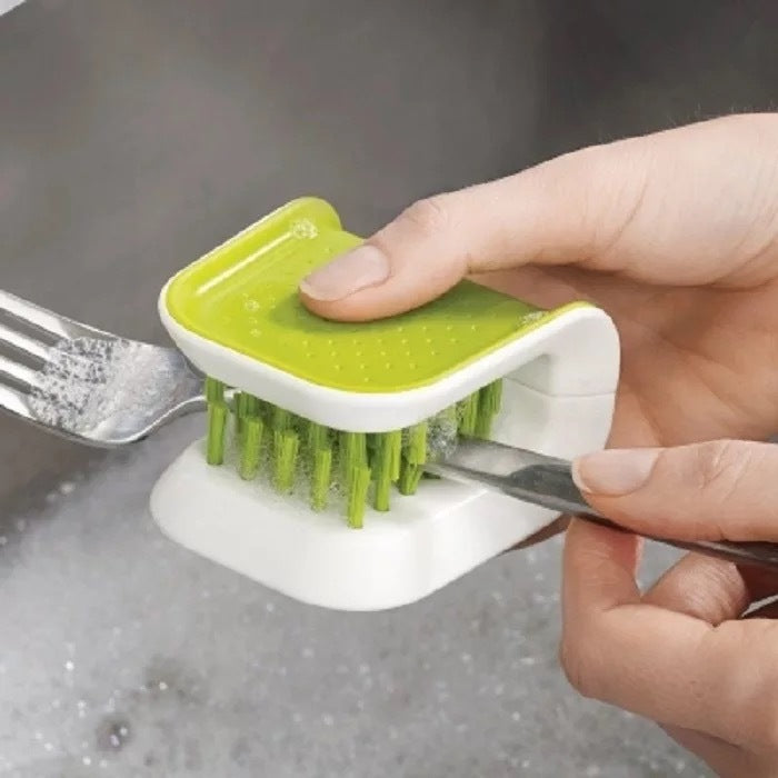 Double-sided cutlery brush cleaning a kitchen knife